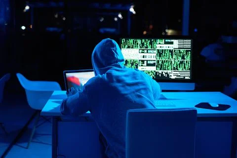 Getting ready to unleash another cyber attack. Rearview shot of a male hacker Stock Photos