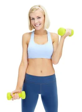 Getting shape makes her feel great. Sporty young woman lifting dumbbells while Stock Photos