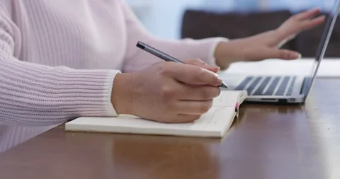 Getting things done from home. 4k video footage of a woman making notes while Stock Footage 201122218