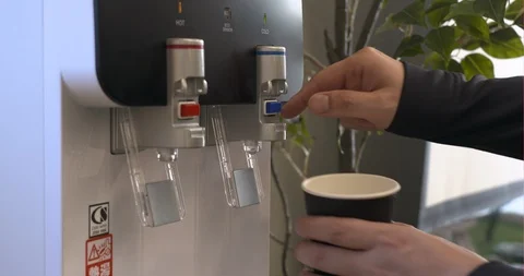 Getting water from a water server in office Stock Footage 122091009