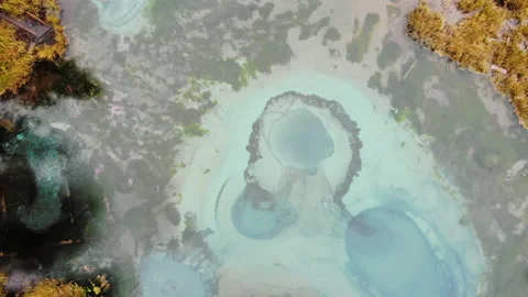 Geyser lake with bizarre bottom, small pond surrounded by forest, aerial Stock Footage 140033577