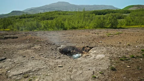 Geysir erupts with force under a clear blue sky in Haukadalur Valley, Iceland. Stock Footage 293638107