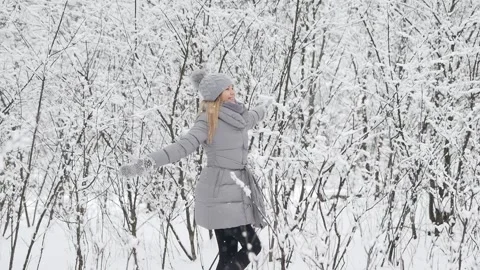 Ggirl in the forest during a snowfall dances and jumps, catches snowflakes. Stock Footage 130639978