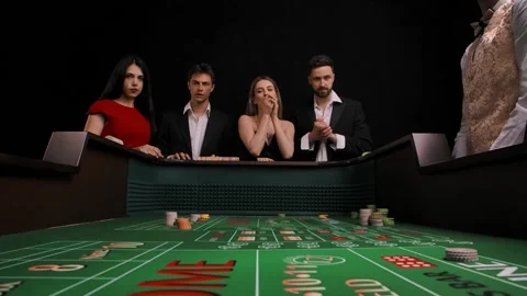 Ggroup of men and women stand at green craps table in casino. Charming lady Stock Footage 155308379