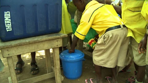GHANA STUDENTS AT LUNCH, DIPS CUP IN WATER AND DRINKS Stock Footage 57830183
