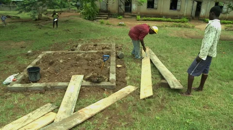 GHANA WIDE ON MAN PULLING NAILS FROM WOODEN BOARD Stock Footage 57830280