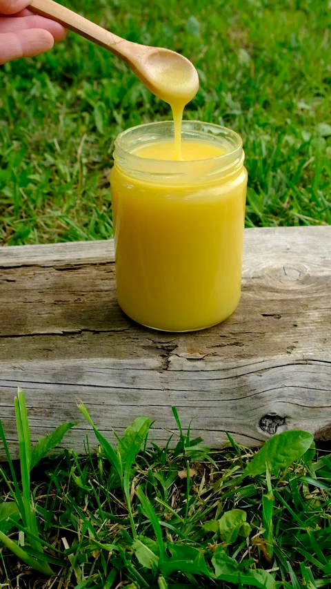Ghee in a jar in a meadow. Selective focus. Stock Footage 319847998