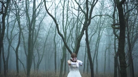 Ghost of the bride walks through the forest in the fog Stock Footage 141898158