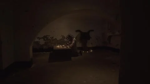 Ghost with cage on his head reading spells next to crucified body in basement. Video stock 245577042