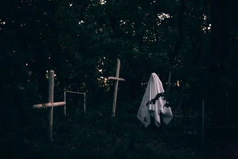 Ghost in the cemetery between graves during Halloween Stock Photos