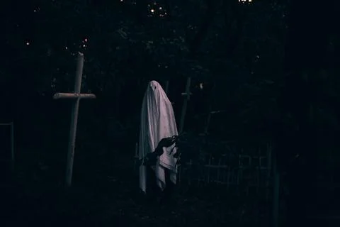 Ghost in the cemetery between graves during Halloween Stock Photos