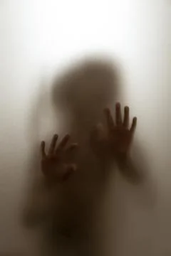Ghost concept shadow of a child behind the matte glass blurry hand and body 写真素材