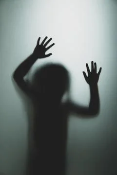 Ghost concept shadow of a child behind the matte glass blurry hand and body Stock Photos