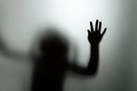 Ghost concept shadow of a child behind the matte glass blurry hand and body Stock Photos