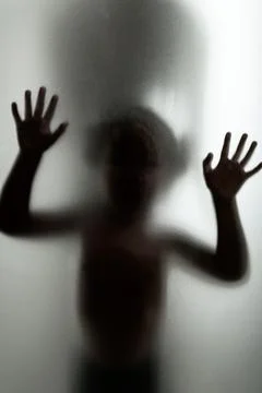 Ghost concept shadow of a child behind the matte glass blurry hand and body 스톡 사진