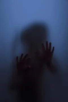 Ghost concept shadow of a child behind the matte glass blurry hand and body Stock Photos