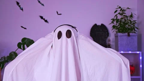 A ghost is dancing at a Halloween party. The ghost listens to music with Stock Footage 218613683