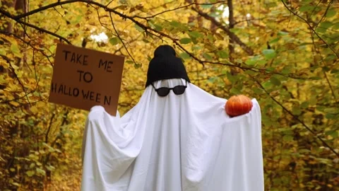 Ghost dancing holding cardboard with text TAKE ME TO HALLOWEEN and pumpkin Vídeos de archivo 278375300