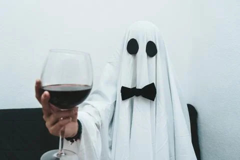 Ghost drinking red wine wearing a formal black bow looking at camera Stock Photos