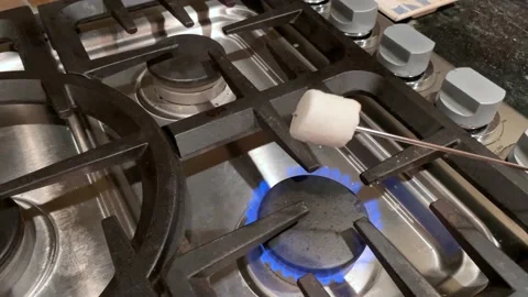 Ghost face marshmallow roasting over a gas stove catches on fire for Halloween Stock Footage 140673398