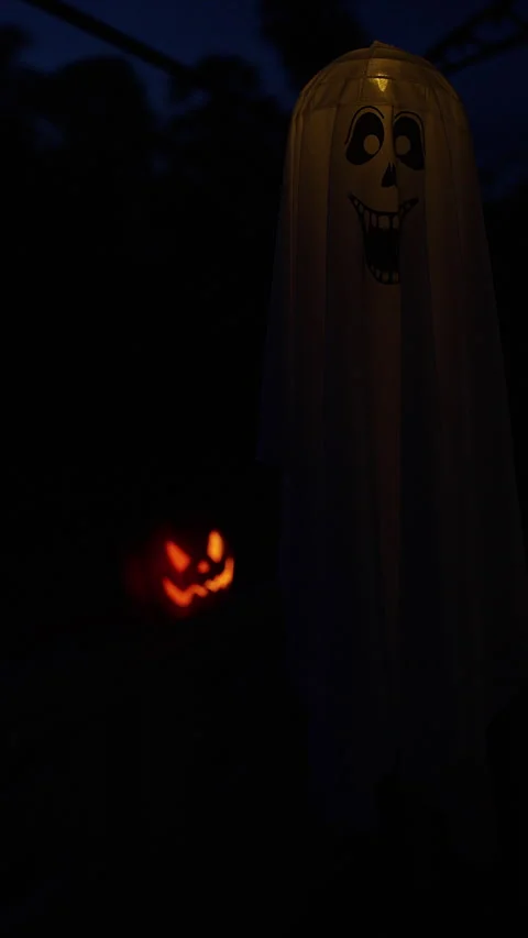 Ghost Figure Standing in Darkness With a Glowing Halloween Pumpkin in the Backgr Stock Footage 337497227
