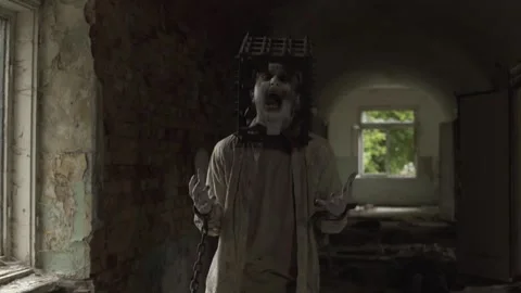 Ghost of maniac with cage on his head squirming in corridor of abandoned asylum Stock Footage 245578038