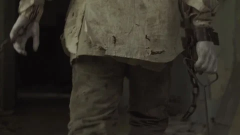 Ghost of maniac with cage on his head dragging dead body down corridor of asylum Stock Footage 245578061