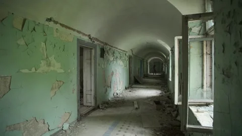 Ghost of maniac with cage on his head walking down corridor of abandoned asylum. Stock Footage 245578977