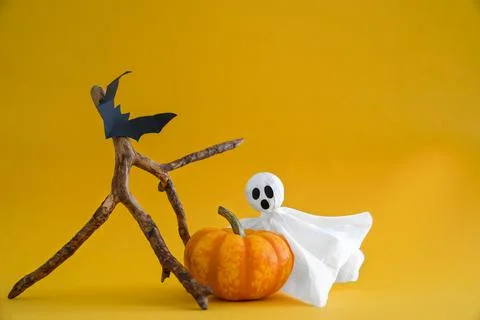 Ghost, pumpkin, bats on orange background with copy space. Stock Photos