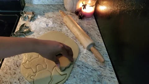 Ghost shaped sugar cookie being cut from dough Stock Footage 213750869