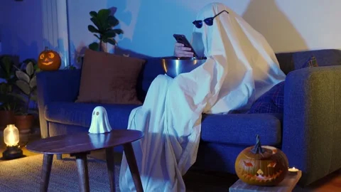 Ghost with sunglasses and popcorn with pumpkins texting at halloween tv movie Stock Footage 278929203