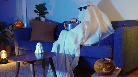 Ghost with sunglasses and popcorn with pumpkins scared at halloween tv movie Stock Footage 278929204