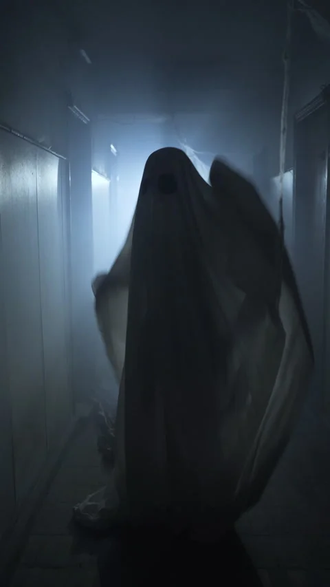 Ghost in white sheet dancing under eerie blue light in dark hallway Stock Footage 313265714