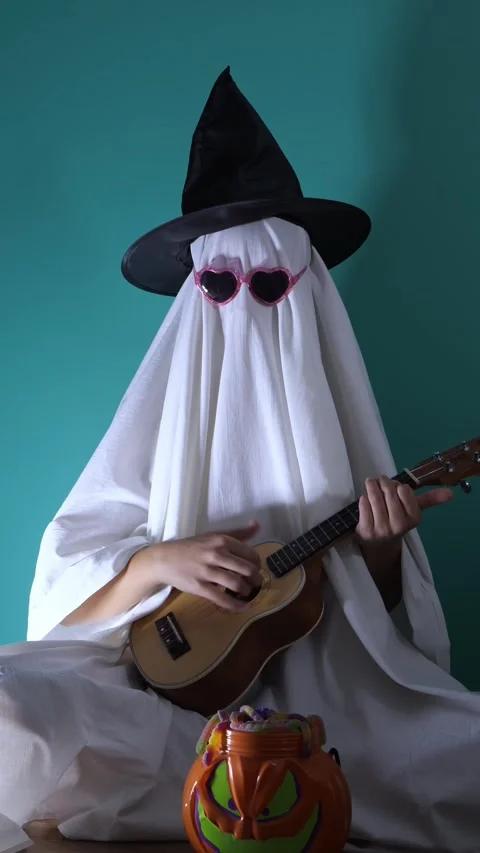 Ghost in witch hat and heart glasses plays guitar for Halloween Vídeos de archivo 342520422