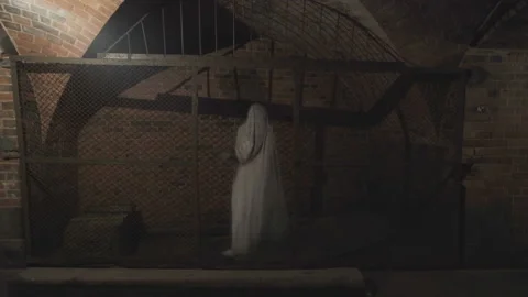 Ghost of woman with  rusty cage on her head  wanders through gloomy corridors.   Video stock 112950237