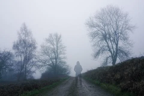 A ghostly transparent figure standing on a path in the countryside Stock Photos