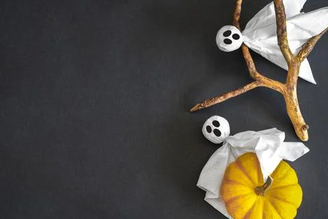 Ghosts with pumpkin on black background. Copy space. Halloween symbols. Stock Photos
