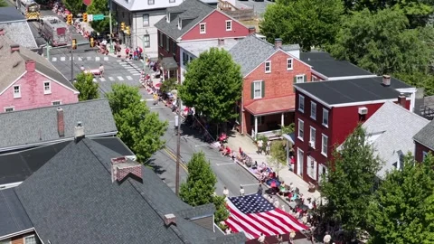Giant American flag carried down parade street lined with crowds plus brick Stock Footage 340298616