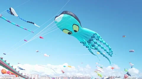 Giant blue octopus kite flying high against a bright blue sky Stock Footage 344769529