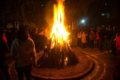 Giant bon fire lit for the festival of Lohri surrounded by people Stock Photos