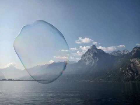 Giant bubble floating above a lake in front of mountains, Switzerland Stock Photos