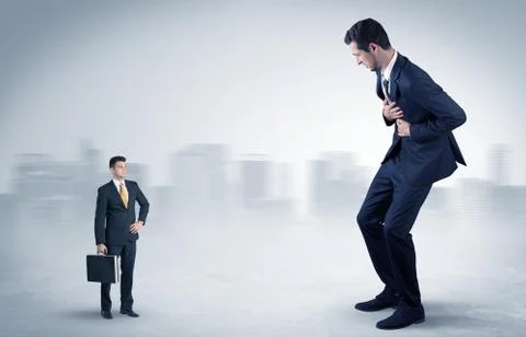 Giant businessman is  afraid of small executor Stock Photos
