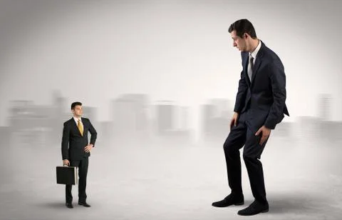 Giant businessman is  afraid of small executor Stock Photos