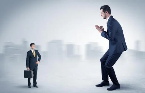 Giant businessman is  afraid of small executor Stock Photos