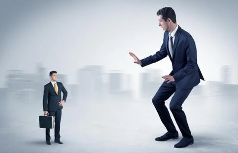 Giant businessman is  afraid of small executor Stock Photos