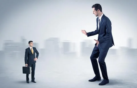 Giant businessman is  afraid of small executor Stock Photos