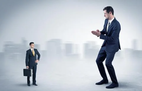 Giant businessman is  afraid of small executor Stock Photos