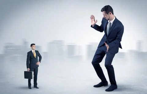 Giant businessman is  afraid of small executor Stock Photos