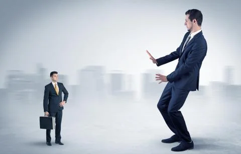 Giant businessman is  afraid of small executor Stock Photos