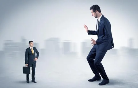 Giant businessman is  afraid of small executor Stock Photos